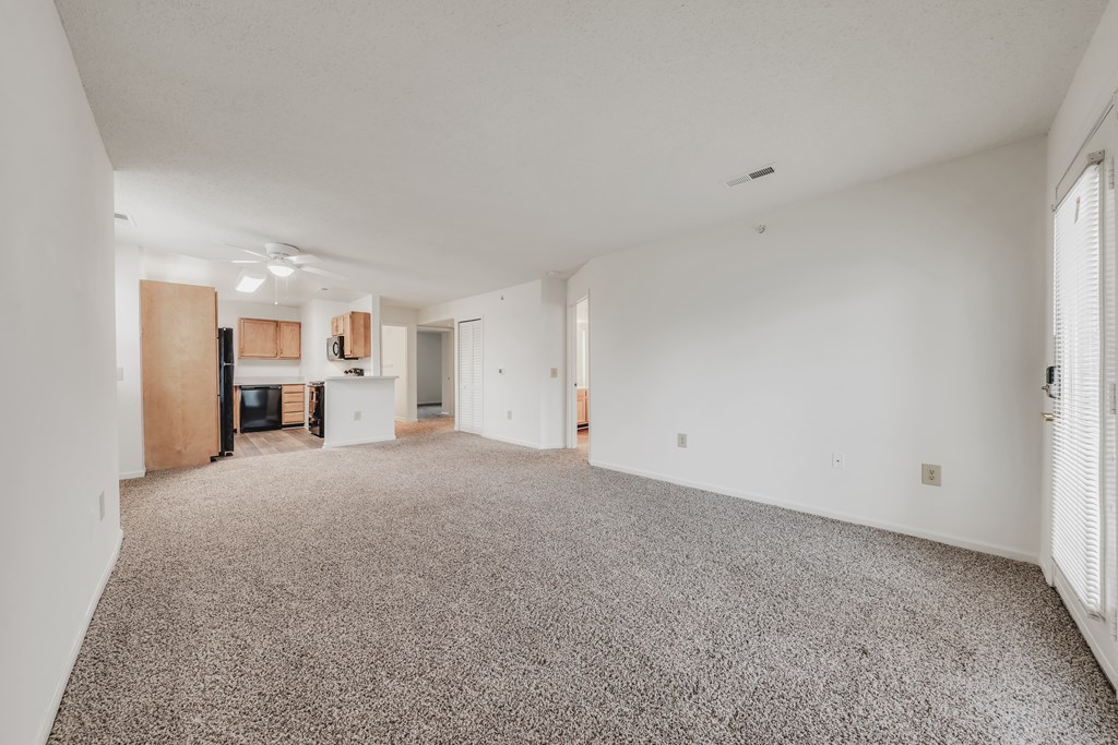 A spacious room with a grey carpet and white walls at WaterFront Apartments, Virginia Beach, 23453