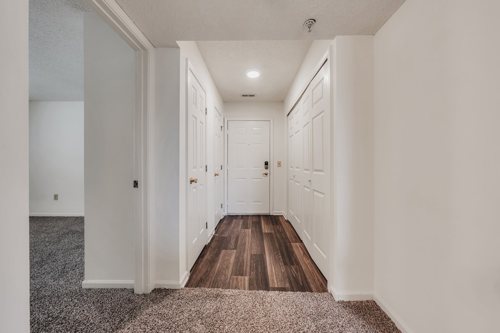 A long hallway with white walls and wood floors at WaterFront Apartments, Virginia Beach, 23453