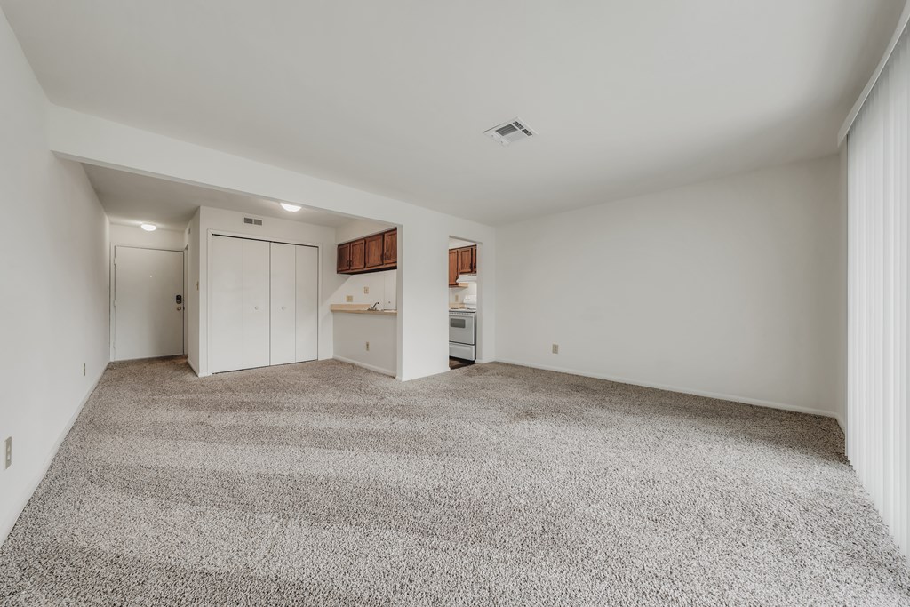 A spacious room with a grey carpet and white walls at WaterFront Apartments, Virginia Beach, 23453
