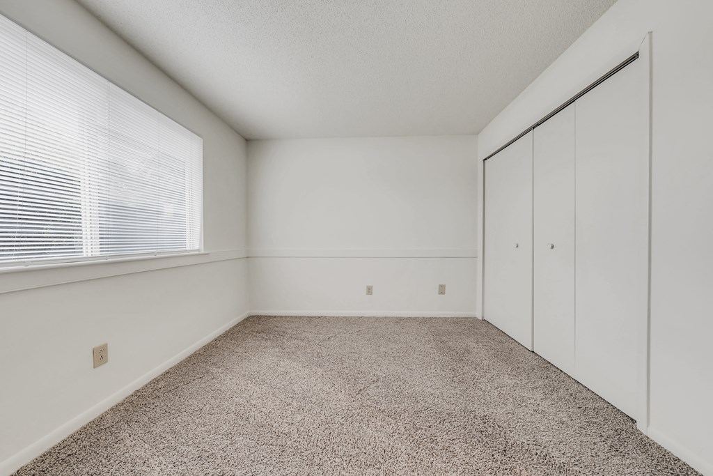 A room with a carpeted floor and a window with blinds at WaterFront Apartments, Virginia Beach, 23453