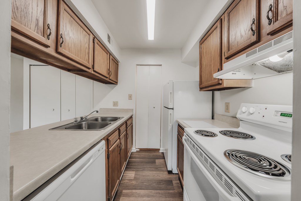 A kitchen with white appliances and wooden cabinets at WaterFront Apartments, Virginia Beach, 23453