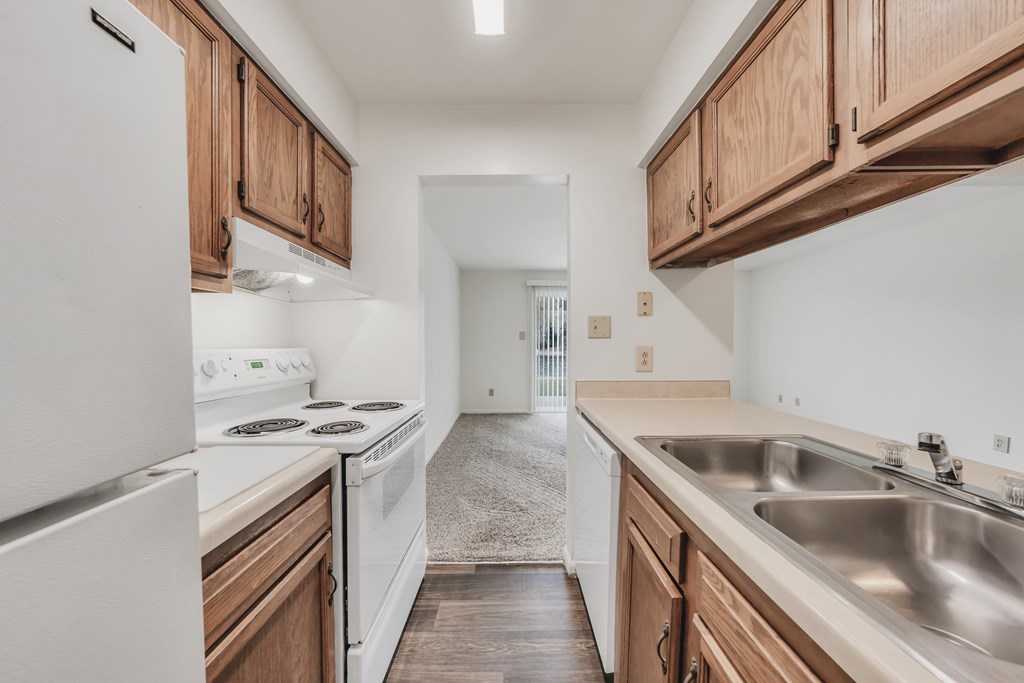 A kitchen with white appliances and wooden cabinets at WaterFront Apartments, Virginia Beach, 23453