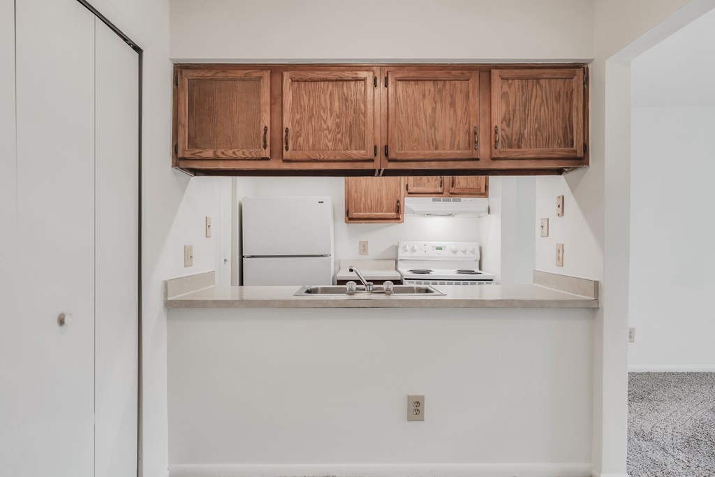A kitchen with wooden cabinets and a stainless steel stove top at WaterFront Apartments, Virginia Beach, 23453