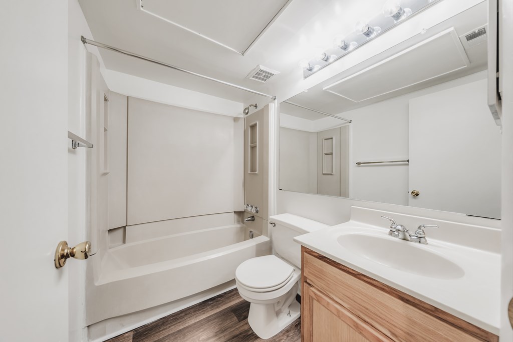 A white bathroom with a toilet, sink, and bathtub at WaterFront Apartments, Virginia Beach, 23453