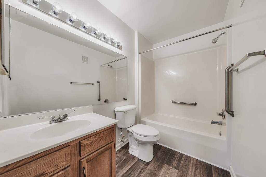 A white bathroom with a toilet, sink, and bathtub at WaterFront Apartments, Virginia Beach, 23453