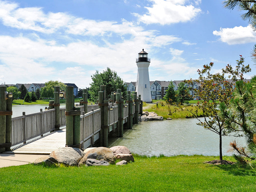 Community Lake with Crossing Bridge and Lighthouse at The Harbours Apartments, Clinton Twp, 48038
