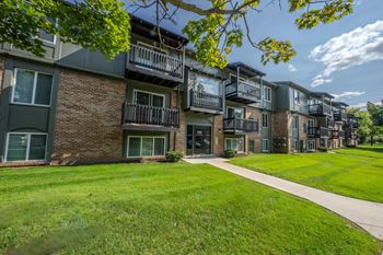 A row of apartment buildings with green lawns in front.