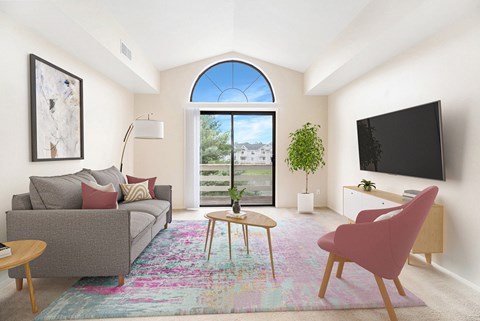 Living room with gray sofa and pink accent chair at Arbor Lakes Apartments, Elkhart, IN 46516