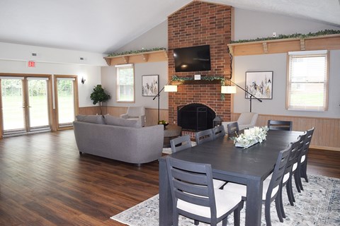 A living room with a grey couch, a black table, and a fireplace.