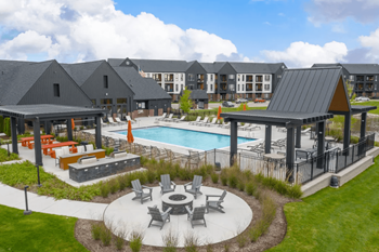 an aerial view of a resort style pool with lounge chairs and a fire pit  at Uptown Square Apartments, Michigan