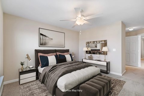 Master bedroom with tufted bench and ceiling fan at Badger Canyon Apartments, Washington