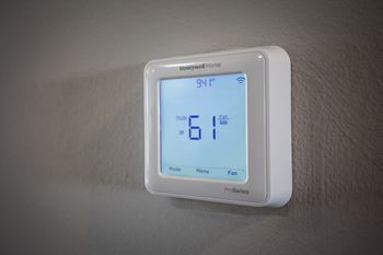 a white thermostat sitting on top of a white wall at Rivers Edge Apartments, Waterford Twp, MI