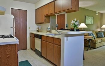 a kitchen with an island and a living room in the background at Beacon Hill and Great Oaks Apartments, Rockford