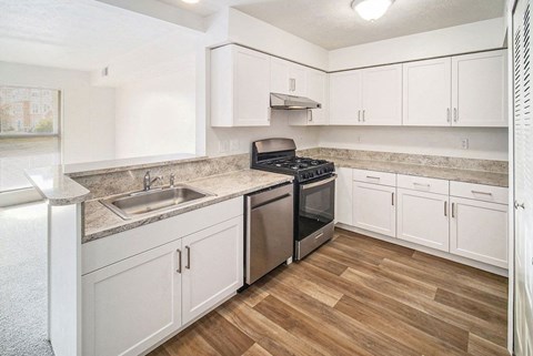 an upgraded kitchen with white cabinets and stainless steel appliances at Black Sand Apartment Homes in Lincoln, NE