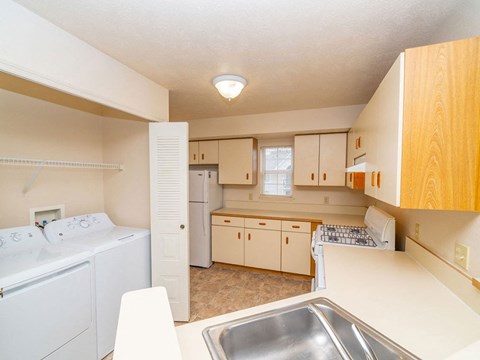 a kitchen with white appliances and wooden cabinets