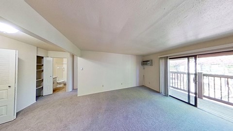 A spacious living room with a private balcony at Briarwood Apartments in Benton Harbor, MI