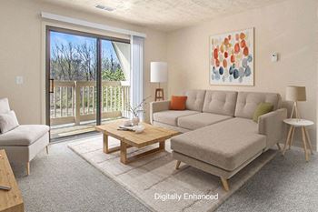 A living room with a couch, and a slider to a balcony at Brookside Apartments, Springfield, MI