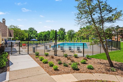 Outdoor swimming pool with lounge chairs and fencing at Brookside Apartments, Springfield