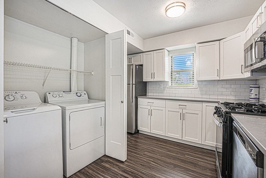 A kitchen with a washer and dryer at Byron Lakes Apartments in Byron Center, MI