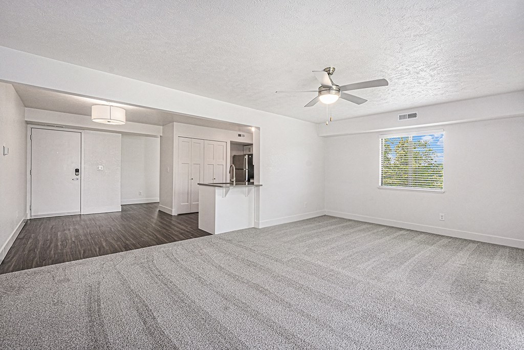 A spacious room with a ceiling fan and carpeted floor at Byron Lakes Apartments in Byron Center, MI