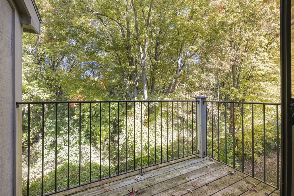 a balcony with a view of trees at Byron Lakes Apartments, Michigan