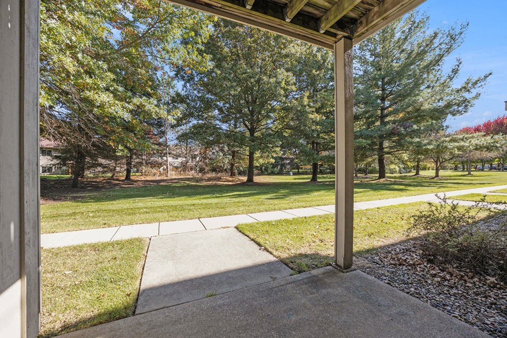a private patio overlooking park like grounds with trees  at Byron Lakes Apartments, Byron Center, MI, 49315