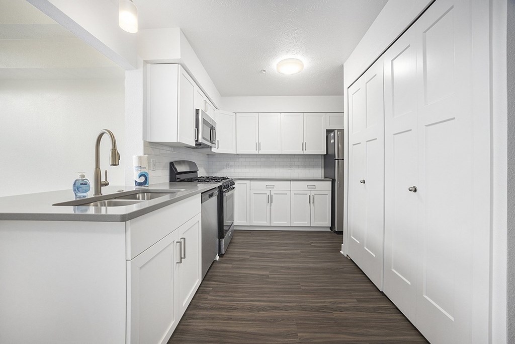 A kitchen with white cabinets and a hard-surface floor at Byron Lakes Apartments, Byron Center, MI