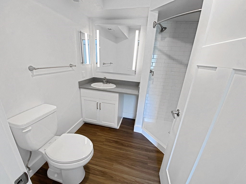 a bathroom with a toilet and a sink and a shower at Byron Lakes Apartments in Byron Center, MI