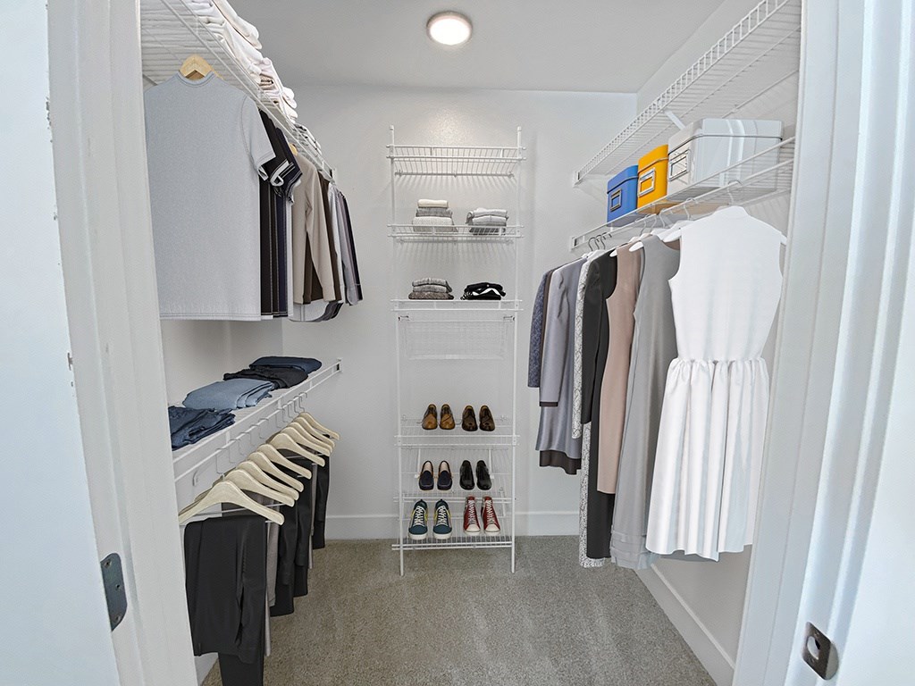 A walk-in closet with clothes and shoes at Byron Lakes Apartments, Michigan, 49315