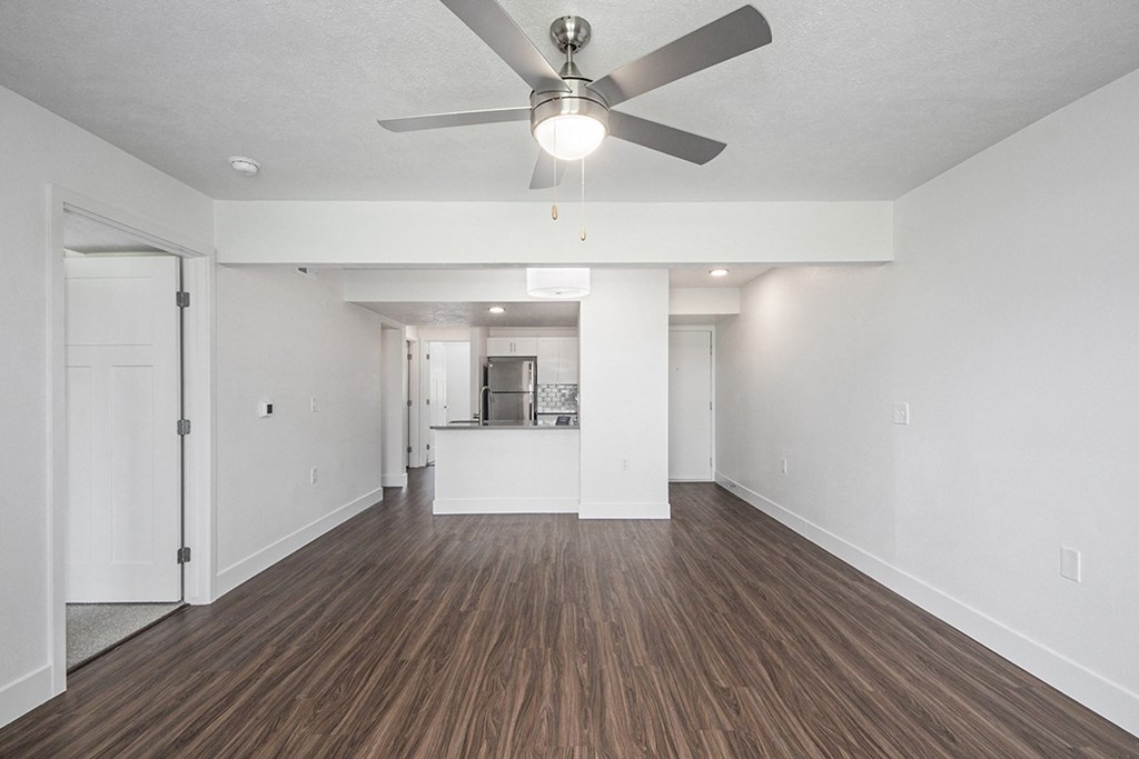 A living room with a ceiling fan and hard surface flooring at Byron Lakes Apartments in Byron Center, MI