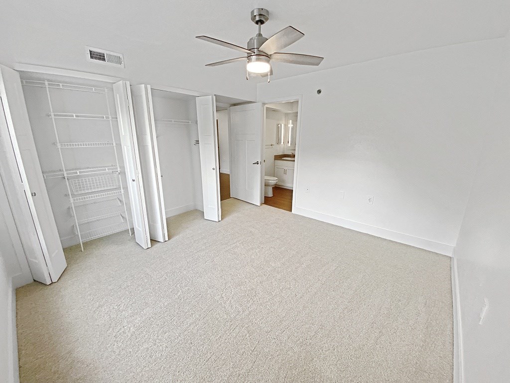 an empty bedroom with a ceiling fan at Byron Lakes Apartments in Byron Center, MI