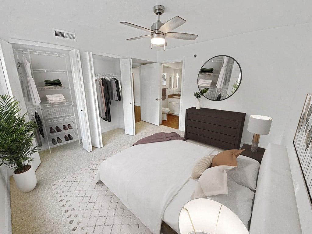A master bedroom with a bed, a ceiling fan, walk-in closet and ensuite bathroom at Byron Lakes Apartments, Michigan, 49315