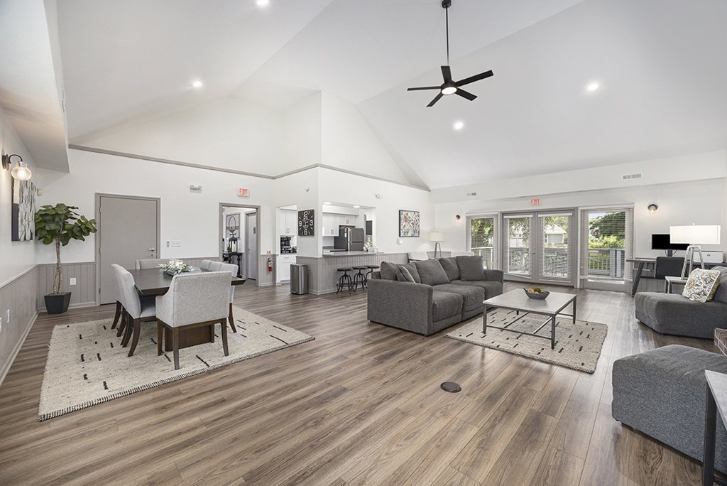 A spacious lounge area with a dining table and grey couches at Byron Lakes Apartments, Byron Center, MI