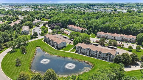 A bird's eye view of a residential area with a lake in the foreground.