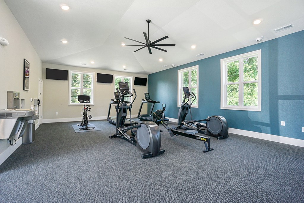 A fitness center with exercise bikes and a television above them at Byron Lakes Apartments in Byron Center, MI