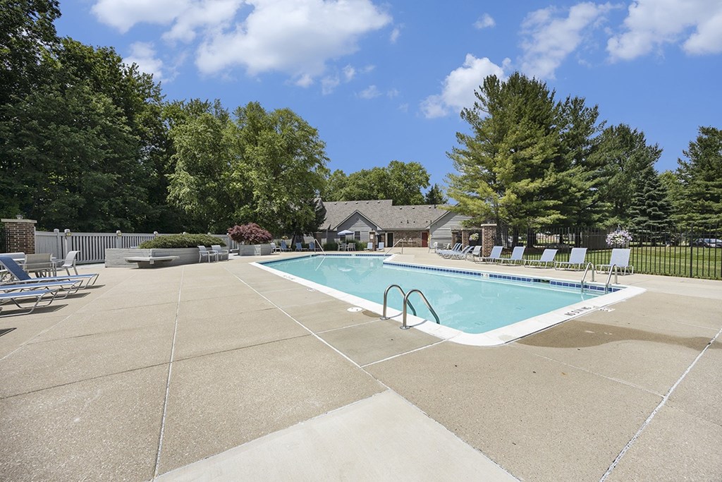 A large swimming pool surrounded by lounge chairs at Byron Lakes Apartments, Byron Center