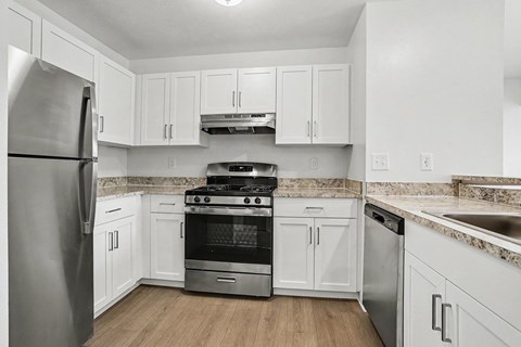 A two bedroom two bath kitchen with white cabinets at Canal Club Apartments, Lansing, MI