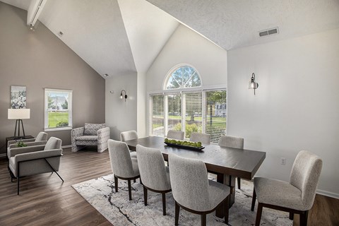 A dining room with a table and chairs.