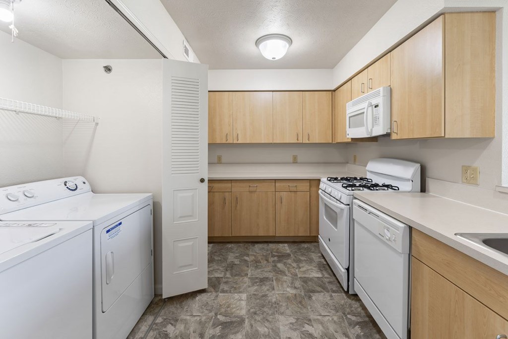 A kitchen with a washer and dryer at Colonial Pointe at Fairview Apartments, Bellevue, 68123