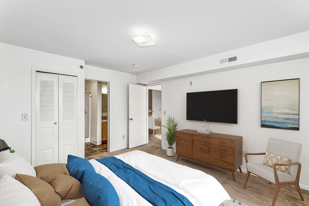 A bedroom with a walk in closet and an attached bathroom at Colonial Pointe at Fairview Apartments, Bellevue, Nebraska