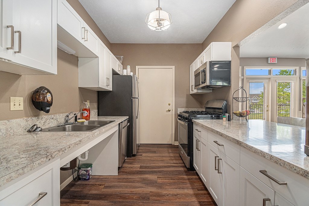 A kitchen with white cabinets in the clubhouse at Colonial Pointe at Fairview Apartments, Nebraska