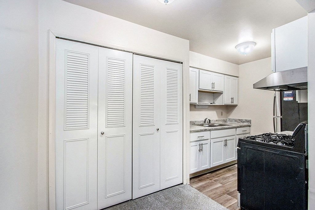 A kitchen with white cabinets and a black stove