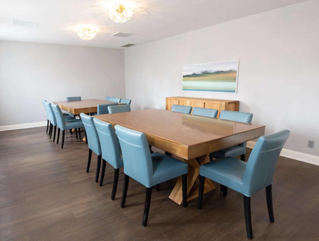 a dining room with a long wooden table and blue chairs a dining room with a long wooden table and blue chairs at Pheasant Run, Lafayette, IN, 47909