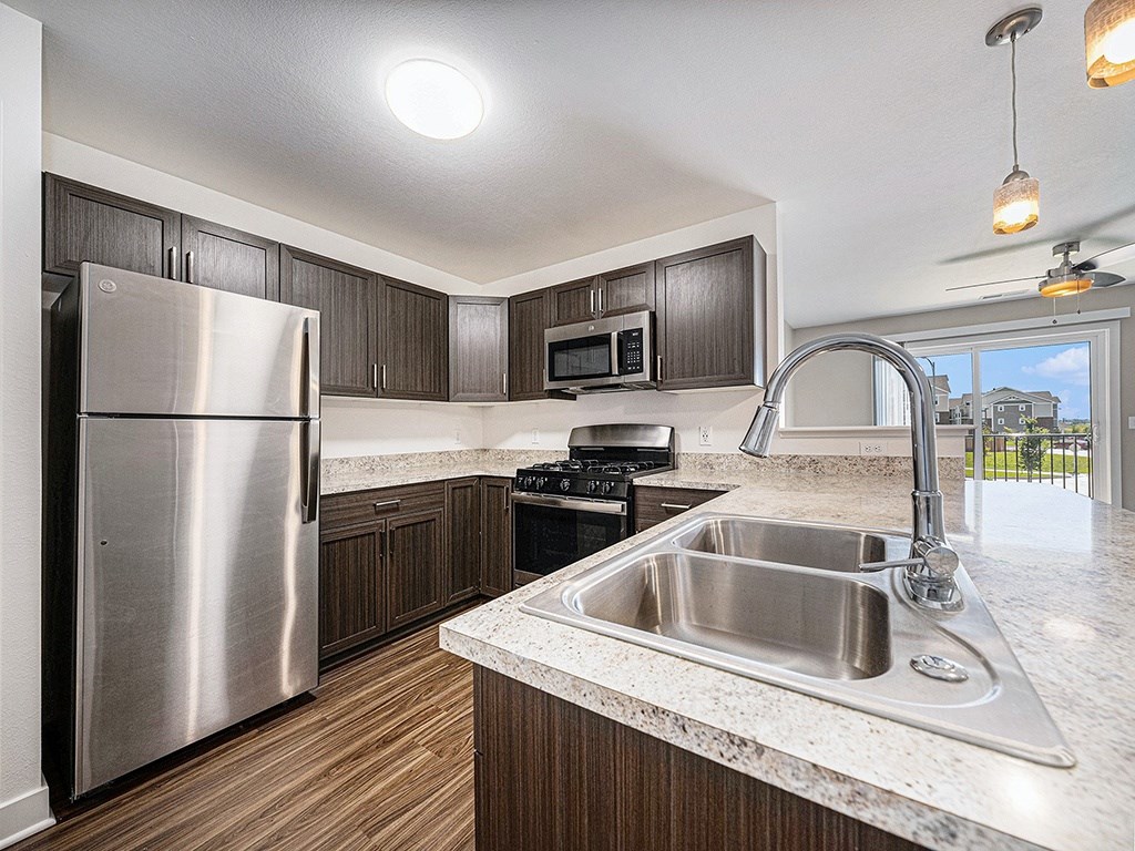 A modern kitchen with a stainless steel refrigerator at Copper Creek Apartment Homes, Maize