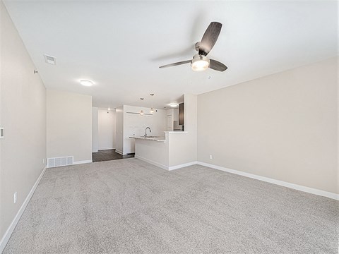 Open floor plan with carpeted living area at Copper Creek Homes Apartments, Maize, KS