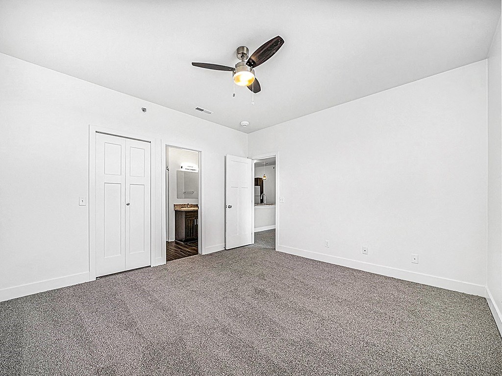 an empty bedroom with a ceiling fan and ensuite at Copper Creek Apartment Homes, Kansas, 67101