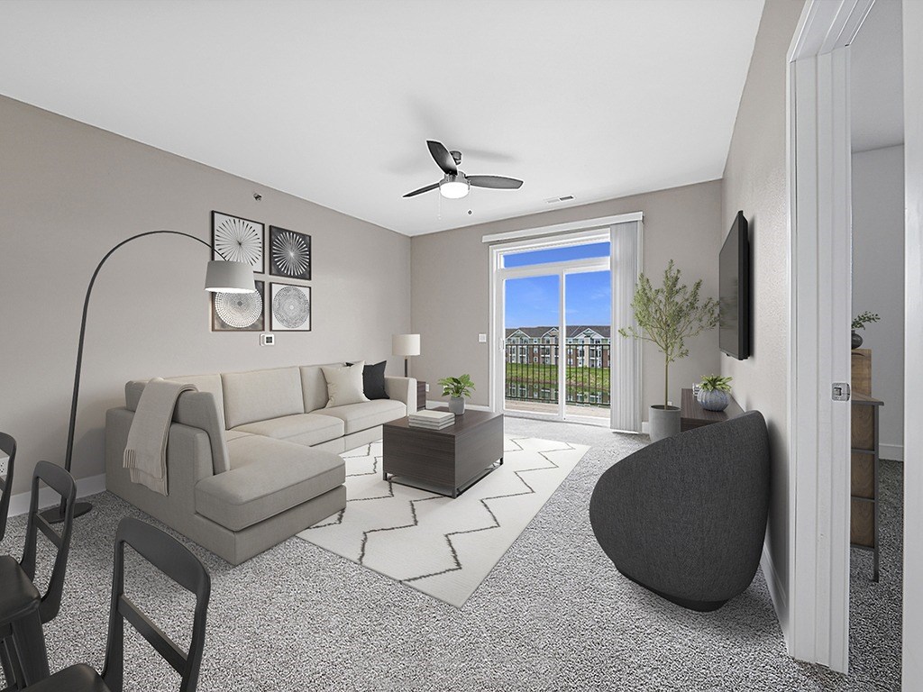 A modern living room with a grey sofa, a black chair, and a television at Copper Creek Apartment Homes, Maize, Kansas
