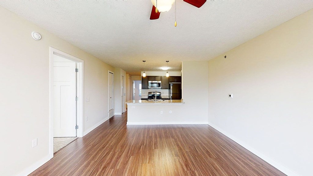 A long, empty living room with hard-surface floors  at Copper Creek Apartment Homes, Maize, Kansas