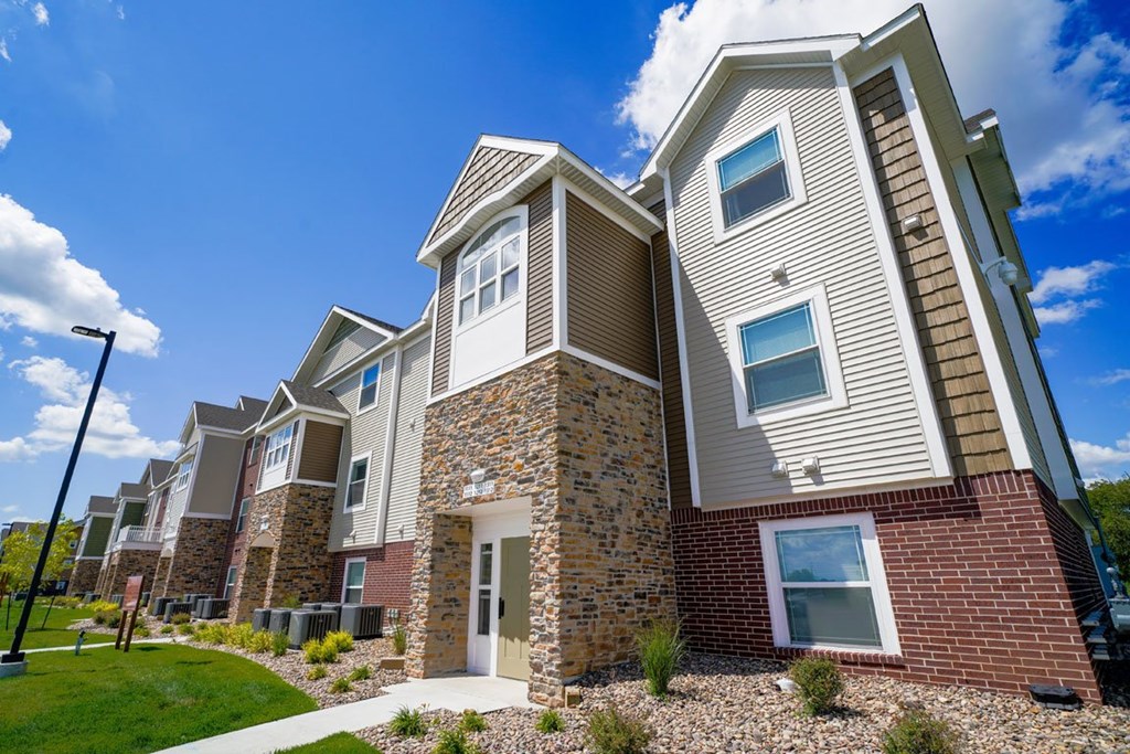 Modern apartment building with a clear blue sky at Copper Creek in Maize, KS 67101