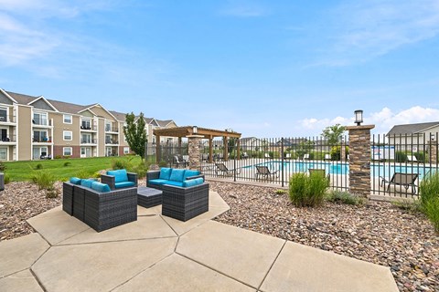 A patio area with a pool and a fence.